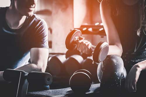 Bodybuilding-Trainer hilft Kunden beim Muskelaufbau