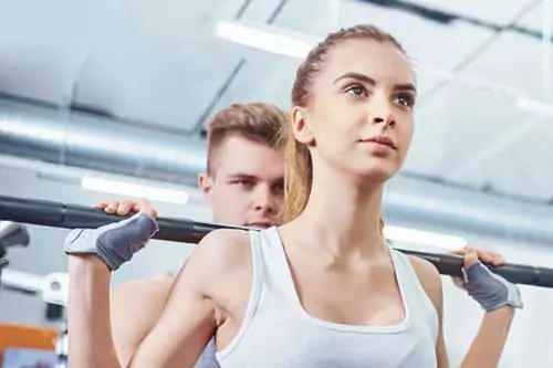 Fitnesstrainer Ausbildung mit A-Lizenz - Frau hebt Gewichte