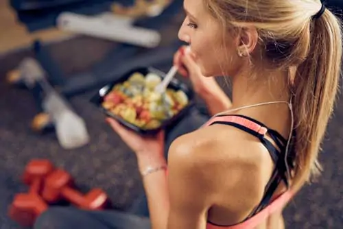 Ernährungsberater für Sportler - Top-Ansicht von Frauen, die gesundes Essen im Fitnessraum essen. Gesunder Lebensstil