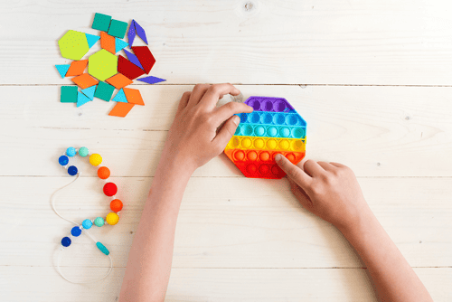 Ergotheraphie | Kinder Hände spielen mit Pop it fidget Spielzeug gegen Stress. Aktivitäten für Feinmotorische Fertigkeiten, Kinderentwicklung und Berufstherapie, Kreativspiel, Therapie Hand
