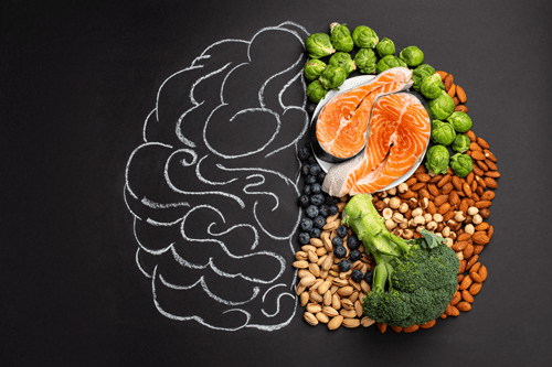 Ganzheitlicher Ernährungsberater | Handgezeichnetes, handgezeichnetes Hirnbild mit einer Vielzahl von Nahrungsmitteln für die Gesundheit des Gehirns und das gute Gedächtnis: frischer Lachs, Gemüse, Nüsse, Beeren auf schwarzem Hintergrund. Lebensmittel zur Steigerung der Hirnleistung