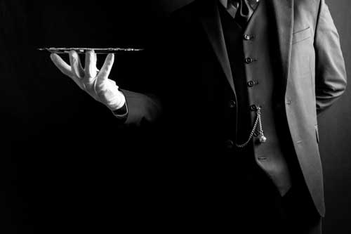 Fachwirt im Gastgewerbe (IHK) | Portrait von Butler oder Kellner in dunklem Anzug und weißen Handschuhen