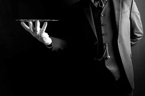 Fachwirt im Gastgewerbe (IHK) | Portrait von Butler oder Kellner in dunklem Anzug und weißen Handschuhen