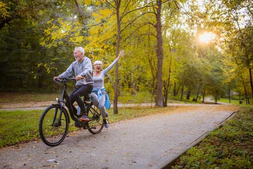 Aktivierung durch Bewegung | Seniorenpärchen fährt auf dem Fahrrad und haben Spaß