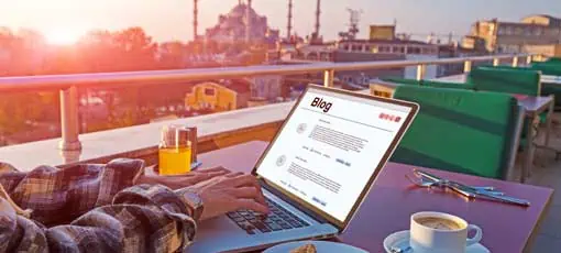 Bloggen - professionell | Reisende, die an Laptop-Computern im Roof Top Café arbeiten, sitzen am Tisch mit Kaffee-Cookies und Orange Juice Istanbul City Landschaft auf Hintergrund Morning Sonnenlicht
