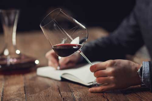 Wein- und Genussexperte (IHK) | Einige männliche Gäste halten eine Glas-Rotwein-Degustationskarte.